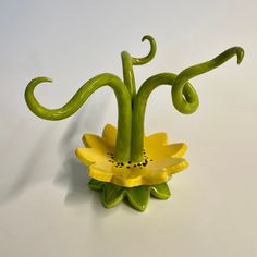 a green vase with yellow flowers on it