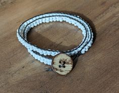 two white beaded bracelets with a wooden button