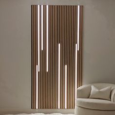 a white chair sitting in front of a wooden paneled wall with lights on it