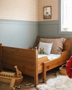 a small child's bed in the corner of a room with toys on the floor