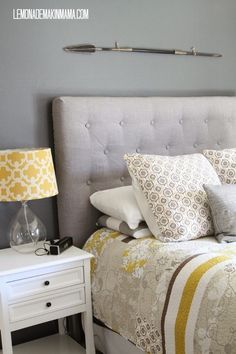 a bed with yellow and white pillows on it