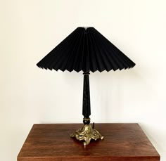 a black lamp sitting on top of a wooden table