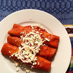 a white plate topped with lots of food on top of a blue and pink table cloth