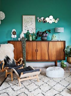 a living room with green walls and white rugs on top of the carpeted floor