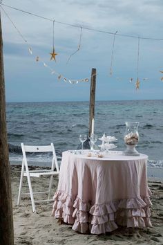 a table set up on the beach for a tea party