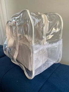 the clear bag is sitting on top of the blue couch