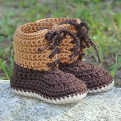 a pair of crocheted boots sitting on top of a rock