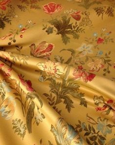 a yellow floral print fabric with red, blue and green flowers on it's side