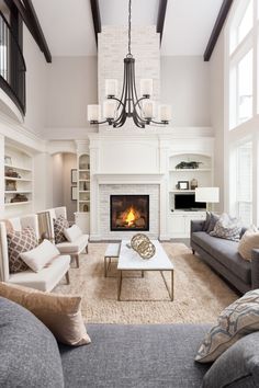 a living room filled with furniture and a fire place in the middle of a room