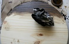 a piece of wood sitting on top of a wooden table next to a black cloth