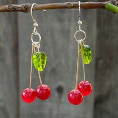 Glass cherry earrings with green leaves Silver-plated dangles  Comes with a silicone backing These stunning cherry earrings are made with translucent beads and are very lightweight. They have silver-plated earring hooks and are hand-made by me, making them the ideal gift to yourself or a loved one!  Jewelry Care: - Keep away from moisture - Put on after applying hair products or lotions - Remove before sleep - Not made for rigorous activity *Stickers included in every order Beaded Cherry, Earrings Food, Glass Fruit, Diy Jewelry Unique, Cherry Earrings, Food Earrings, Fruit Earrings, Before Sleep, Earrings Cute