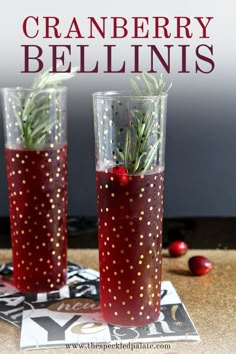 two glasses filled with red liquid and sprinkles on top of a table