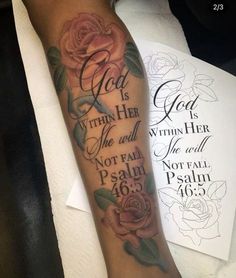 a woman's arm with a rose and bible verse tattoo on it, sitting next to a piece of paper