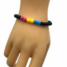 a bracelet with multicolored beads on top of a mannequin's hand