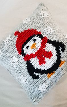 a crocheted pillow with a penguin on it