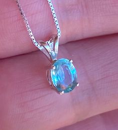 "Beautiful, dainty/minimalist, but will definitely not gone unnoticed, natural, paraiba, and paraiba color: known for its bright neon colours. The colour ranges from blue to green. Stone size: 7*5mm, 0.90 carats, set in 925 sterling silver, with 18\" inches long sterling silver box chain." Blue Round Pendant Jewelry For May Birthstone, Blue Emerald Gemstone Necklace As Gift, Blue Round Pendant For May Birthstone, Blue Emerald Gemstone Necklace For Gift, Dainty Blue Aquamarine Jewelry, Blue Minimalist Aquamarine Jewelry, Green Blue Topaz Jewelry Gift, Green Blue Topaz Jewelry For Gift, Bloodstone Necklace