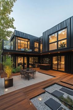 an outdoor dining area with wooden decking and black shipping containers