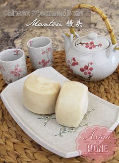 two pieces of bread on a plate with cups and teapots in the background