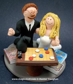 a wedding cake topper sitting next to a game board with a bride and groom on it