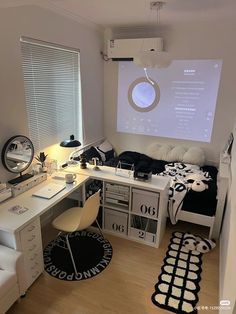 a bedroom with a bed, desk and projector screen on the wall above it