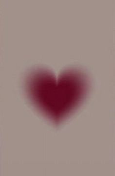 a heart shaped object is shown in the middle of a gray and red background with an overexposed image