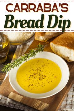 a white bowl filled with bread dip on top of a wooden cutting board next to bread