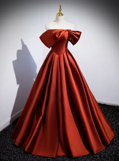 Gaze at the splendor of this striking red prom dress. Are you ready to steal the spotlight with a gown that combines classic elegance and modern flair? This exquisite off-the-shoulder dress features a luxurious satin fabric that drapes beautifully, creating a timeless silhouette. The highlight of the gown is the dramatic oversized bow on the bodice, offering a unique and eye-catching detail that sets this dress apart. The deep red color exudes confidence and sophistication, making it the perfect choice for those who want to stand out. The fitted bodice accentuates your waist, while the voluminous skirt adds a touch of grandeur and movement. Pair this stunning gown with minimalistic jewelry and an elegant updo to complete your glamorous look. Step into your prom night feeling like a star wi Luxury Satin Gown For Red Carpet, Luxury Silk Ball Gown For Evening, Cheap Red Satin Dresses, Red Ball Gown Dresses Satin, Red Satin Dress For Prom Season Banquet, Red Satin Dress For Banquet During Prom Season, Red Satin Finish Evening Dress For Prom, Elegant Red Satin Ball Gown, Satin Off-shoulder Gown For Prom Season