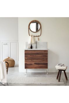 a bathroom with a sink, mirror and stool