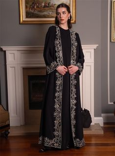 Elevate your modest fashion with this exquisite black abaya, adorned with intricate silver embellishments that add a touch of elegance and sophistication. Perfect for special occasions or formal gatherings, this abaya is designed to make a statement while ensuring comfort and style. The flowing fabric drapes gracefully, providing a modest yet fashionable silhouette. The detailed embroidery along the front and cuffs adds a luxurious feel, making this abaya a must-have for your collection. Pair it Formal Floor-length Embroidered Abaya, Elegant Embroidered Black Abaya, Black Embroidered Abaya For Wedding, Black Embroidered Wedding Abaya, Festive Formal Embellished Abaya, Wedding Black Embroidered Abaya, Black Wedding Thobe For Eid, Traditional Embellished Formal Abaya, Elegant Floor-length Abaya For Eid