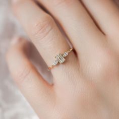 a woman's hand with a diamond ring on top of her finger and an engagement band