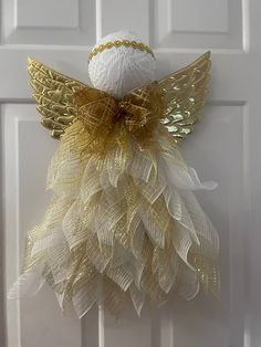 a white door with a gold angel decoration on it