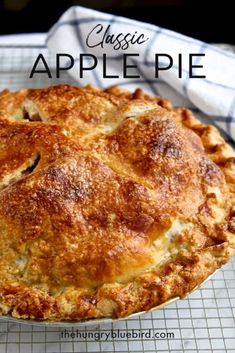 an apple pie sitting on top of a cooling rack with the words classic apple pie above it