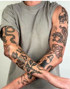 a man with many tattoos on his arm and arms, both holding their hands together