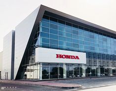 a honda dealership with cars parked in front and on the side of the building