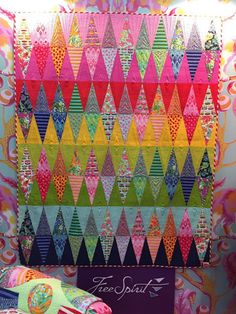 a colorful quilt is hanging on the wall