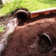 a pipe laying in the ground next to some grass