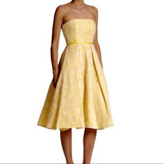 a woman wearing a yellow dress with a bow at the waist and strapless top