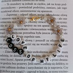 a bracelet with letters and beads on top of an open book