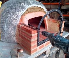 a brick oven being worked on in a workshop