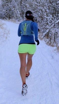 a woman is running in the snow