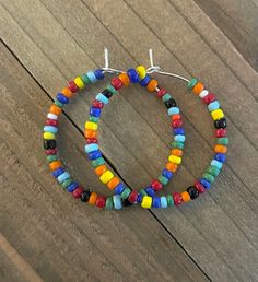 These medium sized hoop earrings are very vibrant and fun.  They are light on the ears and just the right size.  The silver- plated hoops are about 1 1/4 inches in diameter and are made of multicolored glass seed beads.    If there is a color that you do not see I should be able to make a custom pair for you.  Please, message me with your color preference.  *If you would like to buy 2 pair and receive one free,  go to this listing: https://www.etsy.com/listing/1106456212/medium-sized-hoop-earrings-custom-beaded?click_key=4547325c485bf0417bb8b88a0bcb51080bc1e9d5%3A1106456212&click_sum=2b5e1743&ref=shop_home_active_5&pro=1&frs=1 In order to choose your desired color, simply pick the picture that has your color.  Then, choose the number.   All earrings are packaged in a pretty white drawstrin Olive Earrings, Antique Silver Earrings, Boho Hoop Earrings, Handmade Hoop Earrings, Medium Hoop Earrings, Earrings Colorful, Dangle Hoop Earrings, Earring Gift, Jewelry Earring