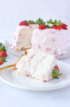 a slice of strawberry cake on a plate with strawberries next to it and the rest of the cake in the background