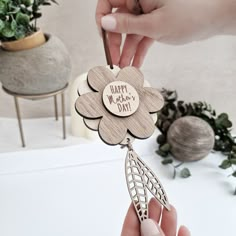 a person holding a flower shaped keychain with the words happy mother's day on it