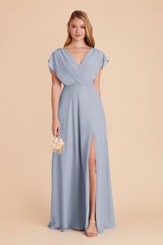 a bridesmaid in a blue dress with a slit down the side, holding a bouquet