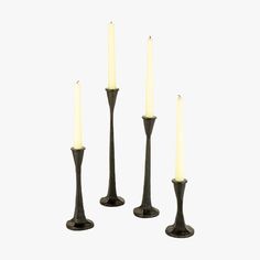 four black candlesticks with one lit and the other turned off in different directions