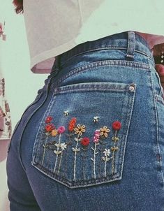 the back of a woman's jeans with flowers embroidered on it and in between her butts