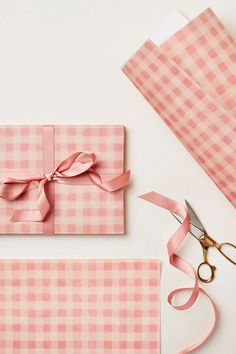 pink wrapping paper with ribbon and scissors next to it