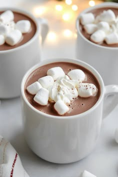 two mugs filled with hot chocolate and marshmallows