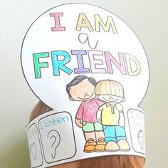 a child wearing a paper hat with the words i am a friend on it