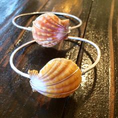 "These beautiful beachy bangles are a custom order item to fit you perfectly! A lovely, one of a kind, Hawaiian sunrise shell adorns it. These shells vary in color and size, so please let us know your preference! These bangles are made on 14 gauge gold fill wire or 12 gauge sterling silver. To measure your hand for these, make a duck bill and measure the largest part of your hand from the top of your middle finger knuckle to the base of your thumb. 8\" is a \"typical\" bangle size. Since this is Beach Wire Wrapped Shell, Beachy Shell Bracelets As Gifts, Unique Beach Bangle Jewelry, Ocean-inspired Shell Bracelets For Beach Season, Adjustable Handmade Bangle For Beach, Ocean-inspired Wire Wrapped Shell, Handmade Shell Bracelet With Ocean-inspired Style, Handmade Shell Bracelet, Ocean-inspired, Handmade Shell Bracelet Ocean-inspired